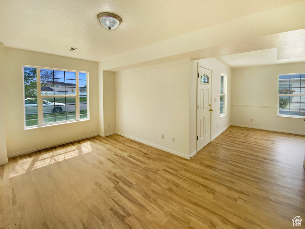 Spare room featuring light wood-type flooring and baseboards