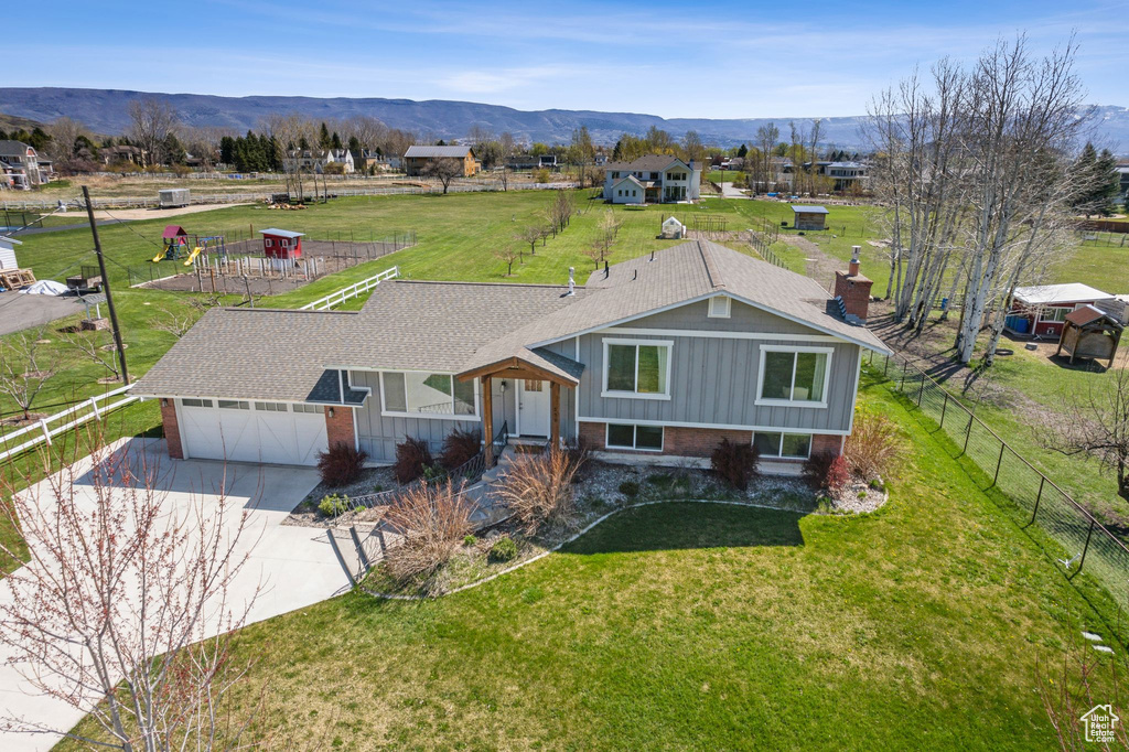 View of front facade featuring fence, a chimney, and a mountain view