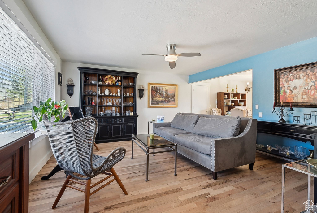Living area with light wood-type flooring and ceiling fan
