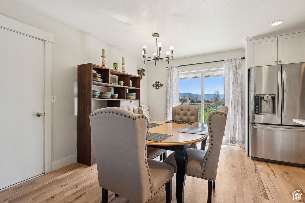 Dining area featuring baseboards, an inviting chandelier, light wood finished floors, and recessed lighting