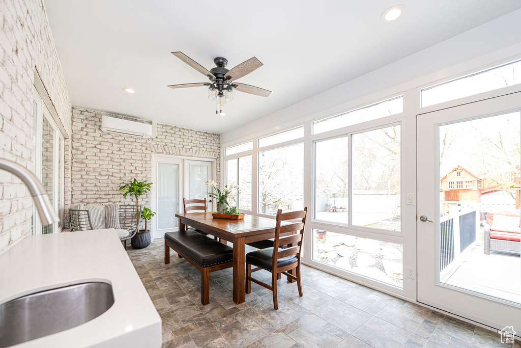 Sunroom / solarium with brick wall, a sink, a wall mounted AC, and recessed lighting