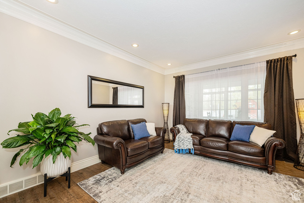 Living area featuring baseboards, visible vents, recessed lighting, wood finished floors, and ornamental molding