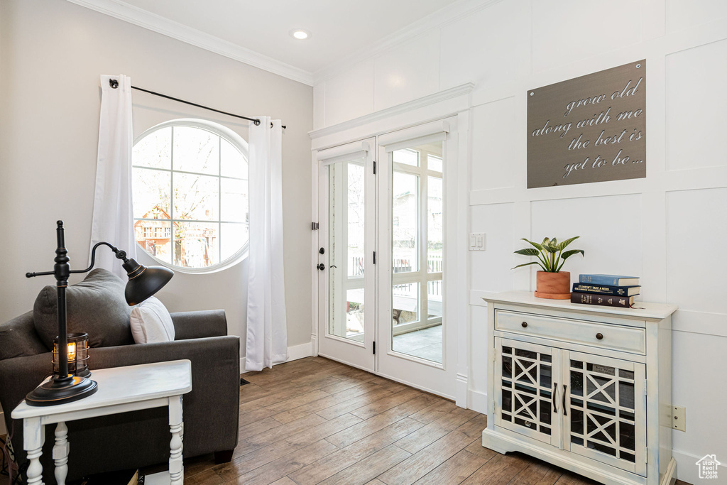 Doorway featuring hardwood / wood-style flooring, a wealth of natural light, ornamental molding, and recessed lighting