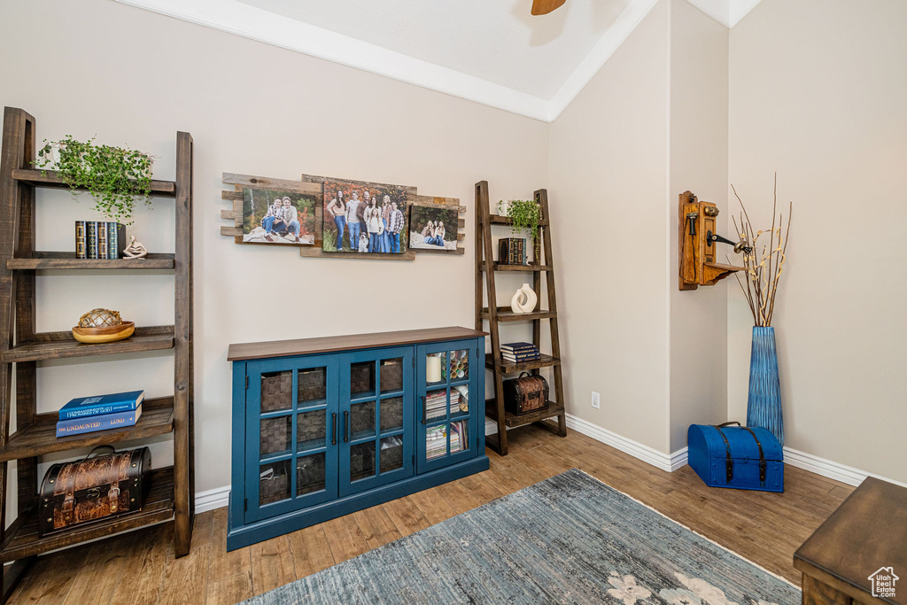 Interior space with lofted ceiling, a ceiling fan, baseboards, and wood finished floors