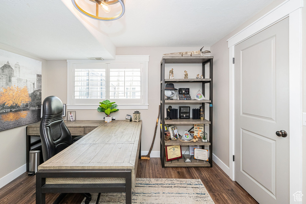 Office space featuring dark wood finished floors and baseboards