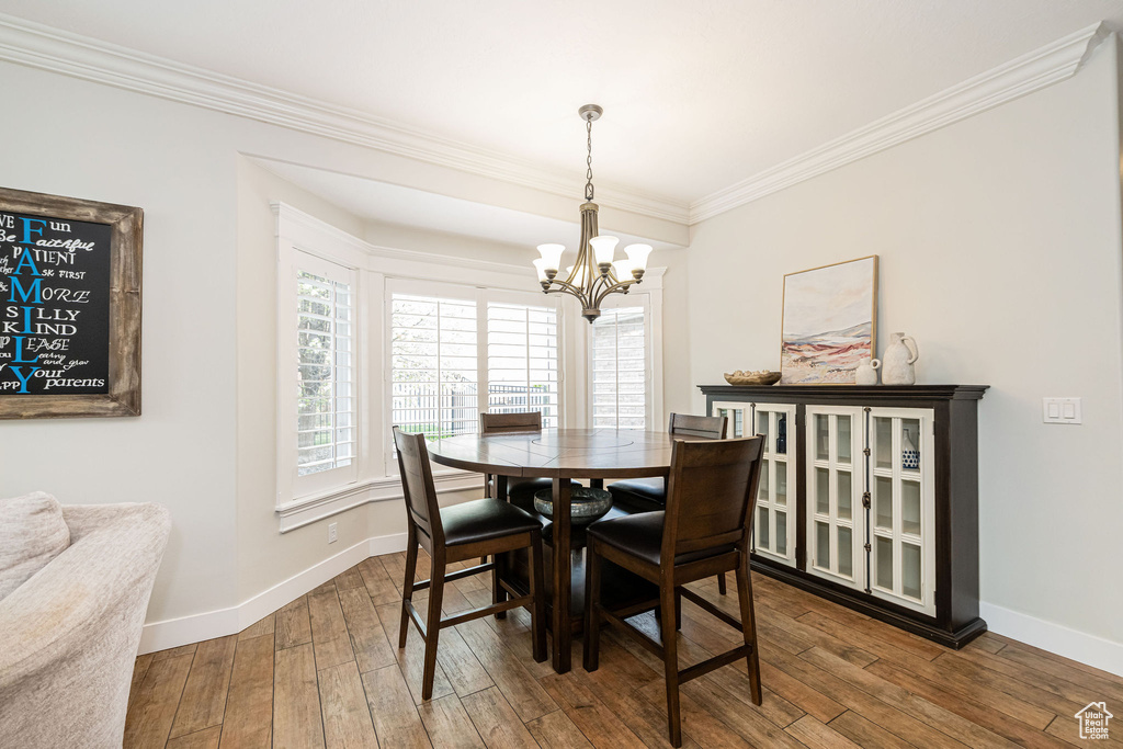 Dining space featuring a chandelier, plenty of natural light, crown molding, and baseboards