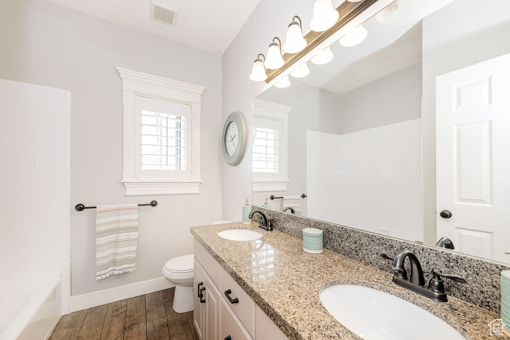 Bathroom with visible vents, toilet, baseboards, and a sink