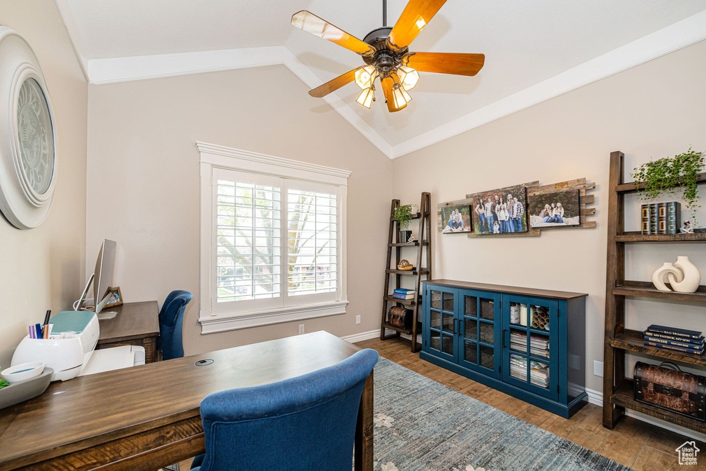 Home office featuring lofted ceiling, a ceiling fan, wood finished floors, and baseboards