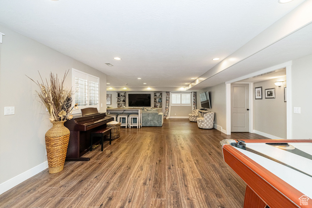Living room featuring baseboards, recessed lighting, and dark wood-type flooring