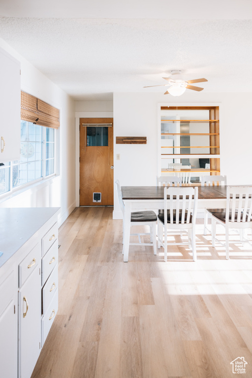 Dining room with light wood-type flooring, visible vents, and ceiling fan