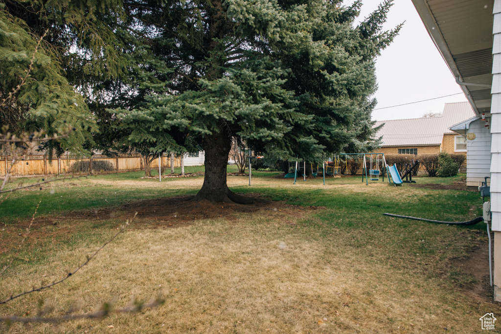 View of yard with fence and a playground