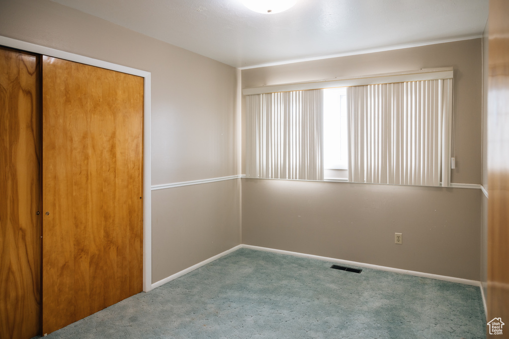 Unfurnished bedroom with baseboards, a closet, visible vents, and carpet