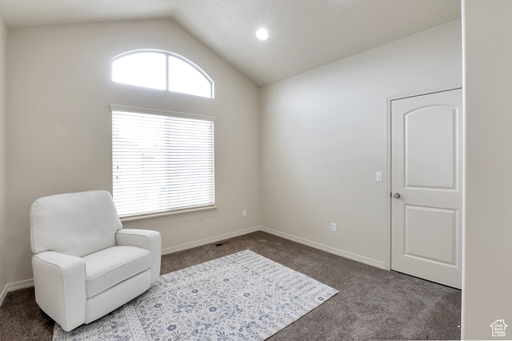 Sitting room with vaulted ceiling, baseboards, and carpet