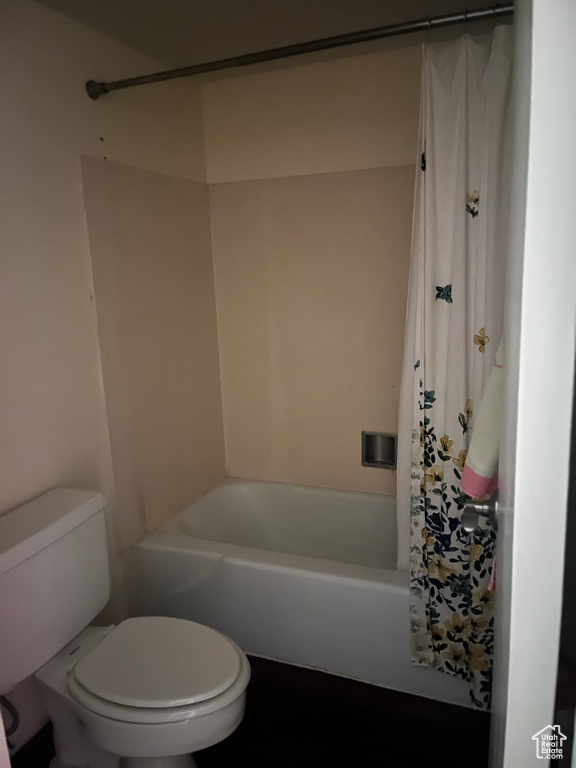 Full bath featuring toilet and shower / bath combination with curtain