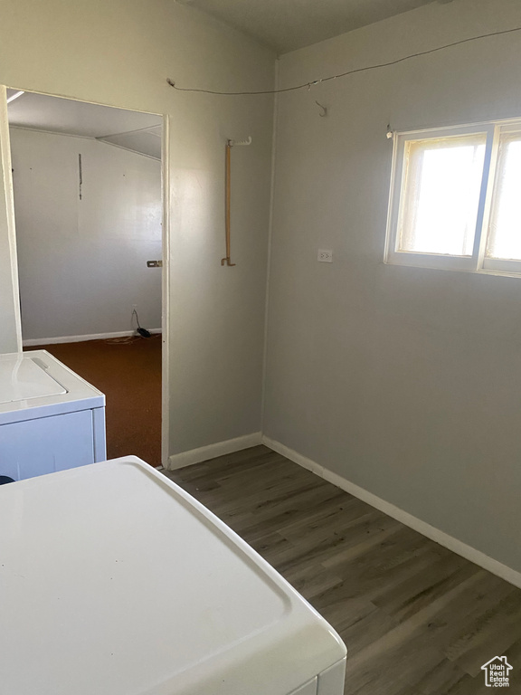 Unfurnished bedroom with baseboards, wood finished floors, and washer and dryer