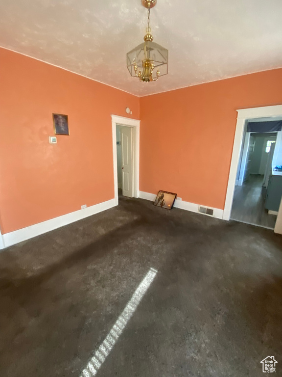 Interior space with baseboards, carpet flooring, a chandelier, and visible vents