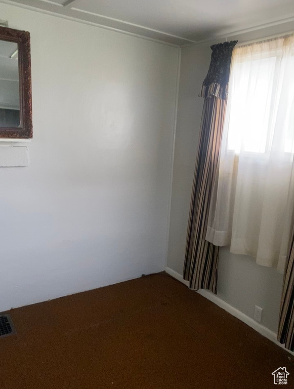 Empty room featuring carpet flooring and visible vents