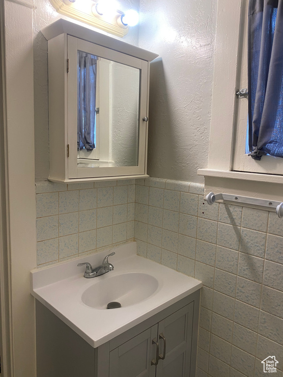 Bathroom featuring vanity and tile walls