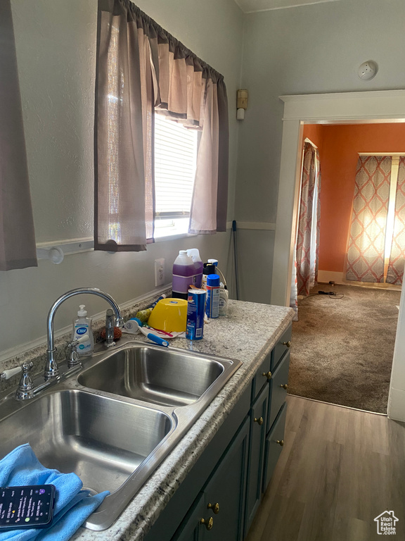 Kitchen with light countertops, wood finished floors, and a sink