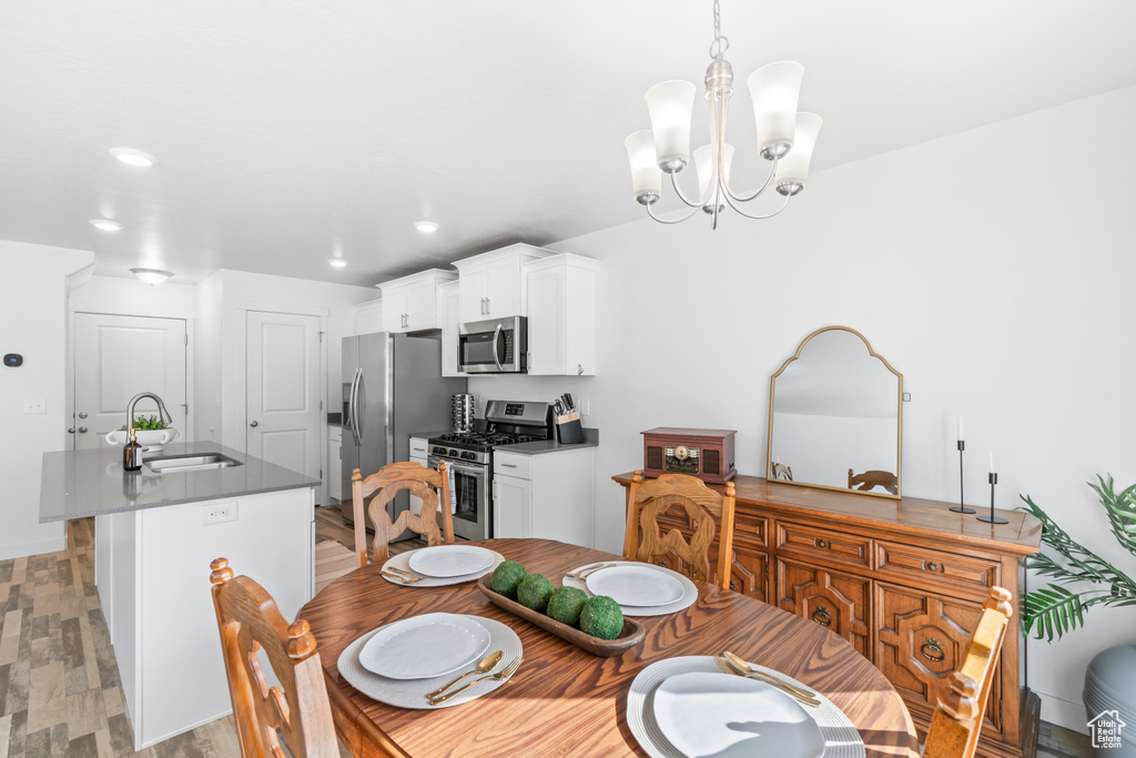 Dining area with an inviting chandelier, light wood finished floors, and recessed lighting