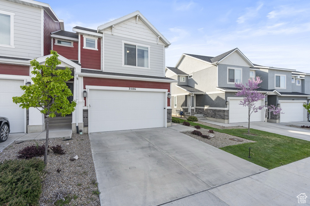 View of front facade with concrete driveway, a residential view, and a garage