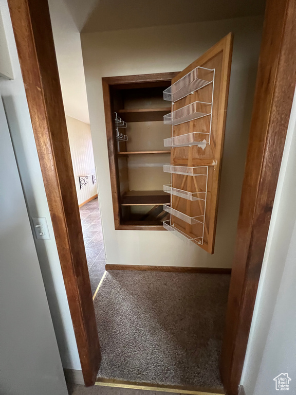 Corridor featuring baseboards and carpet flooring