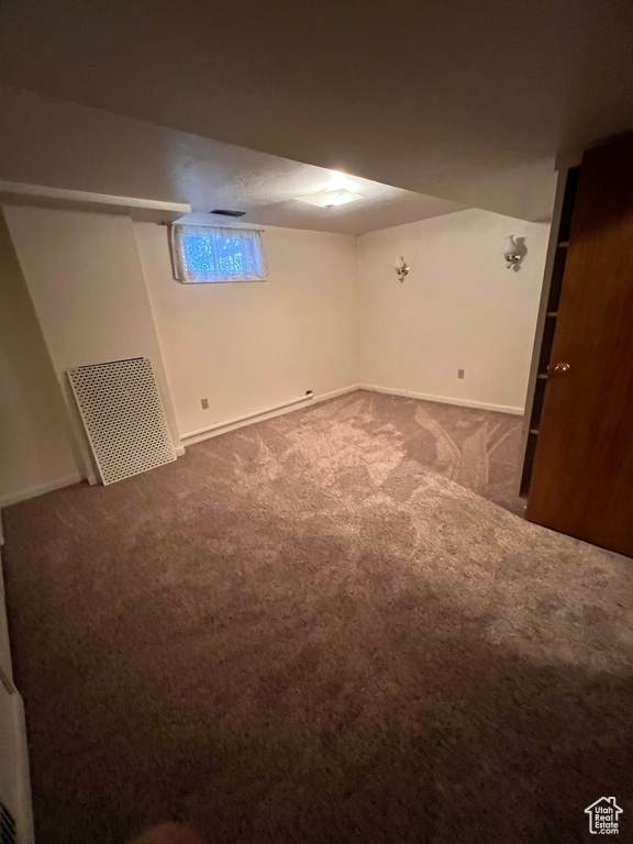 Basement featuring carpet flooring and baseboards