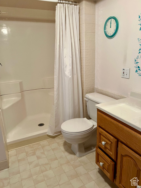 Bathroom with vanity, a shower stall, and toilet