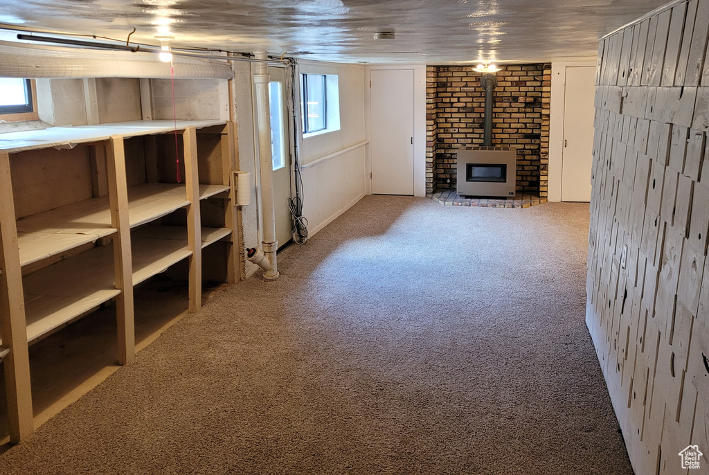 Basement with carpet flooring and a wood stove