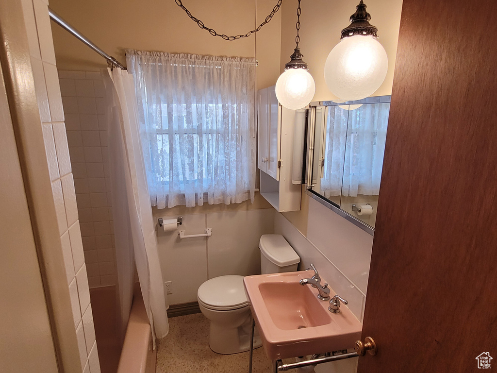 Full bath with a sink, toilet, and shower / tub combo
