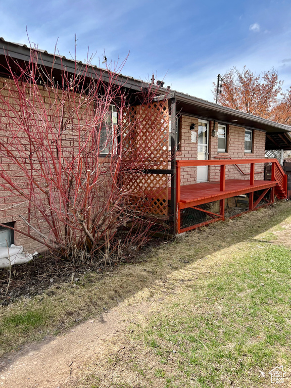 Rear view of property with a yard and a deck