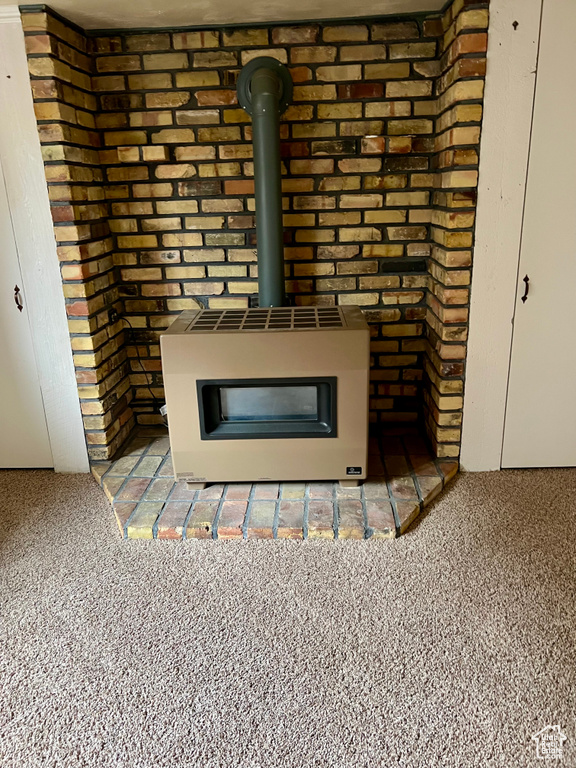 Room details with carpet floors and a wood stove