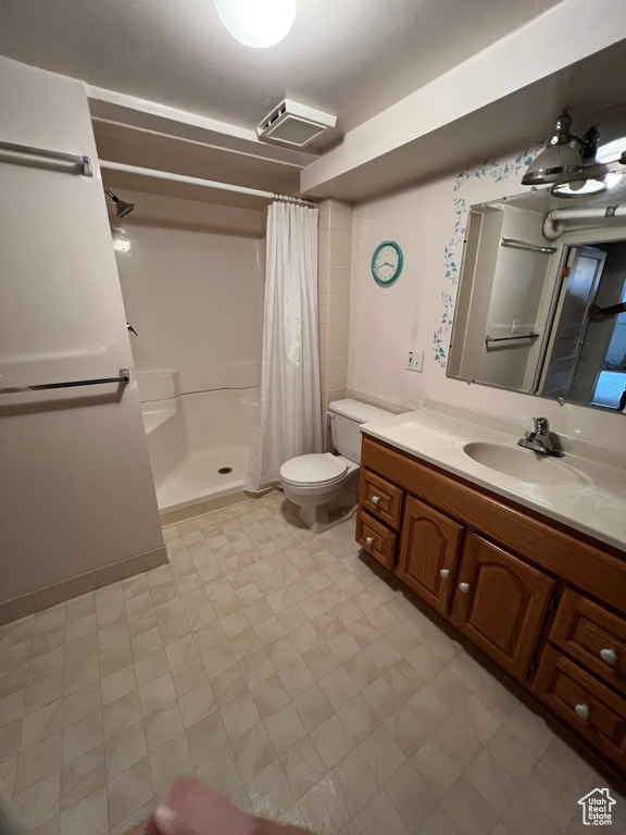 Full bath with a shower with shower curtain, toilet, and vanity