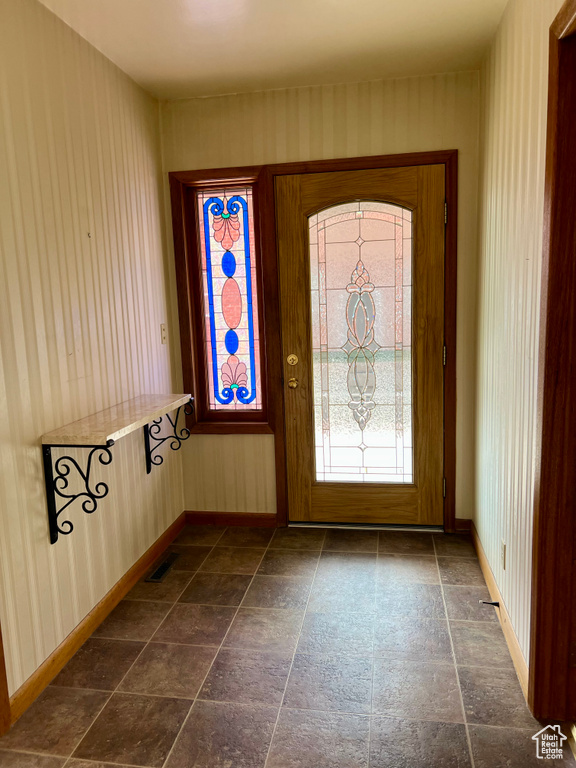 Foyer featuring visible vents, wallpapered walls, and baseboards