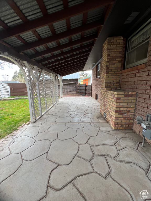 View of patio / terrace with fence and a carport