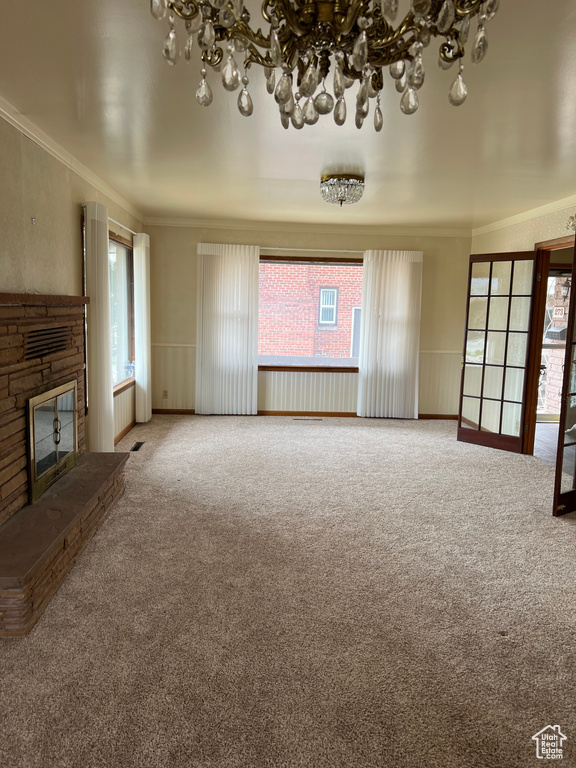 Unfurnished living room featuring ornamental molding, carpet flooring, and a healthy amount of sunlight
