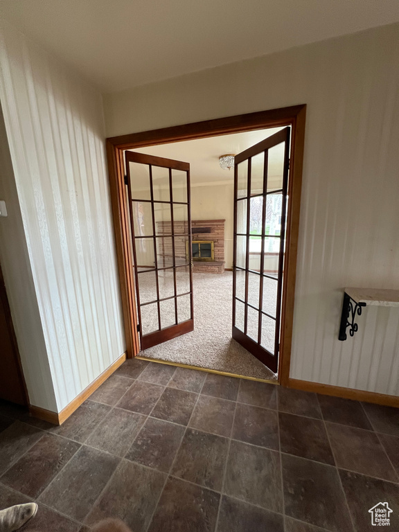 Doorway to outside with a brick fireplace and baseboards