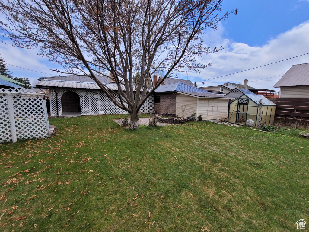 Rear view of property with an exterior structure, an outbuilding, a chimney, and metal roof