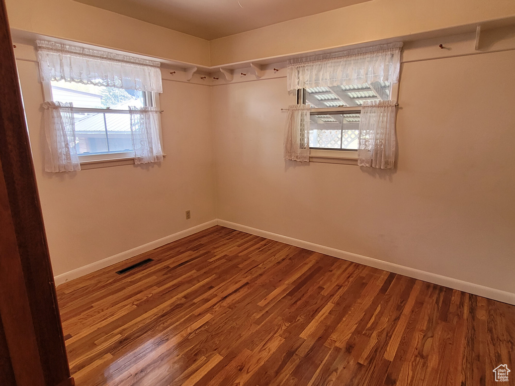 Spare room with baseboards and wood finished floors