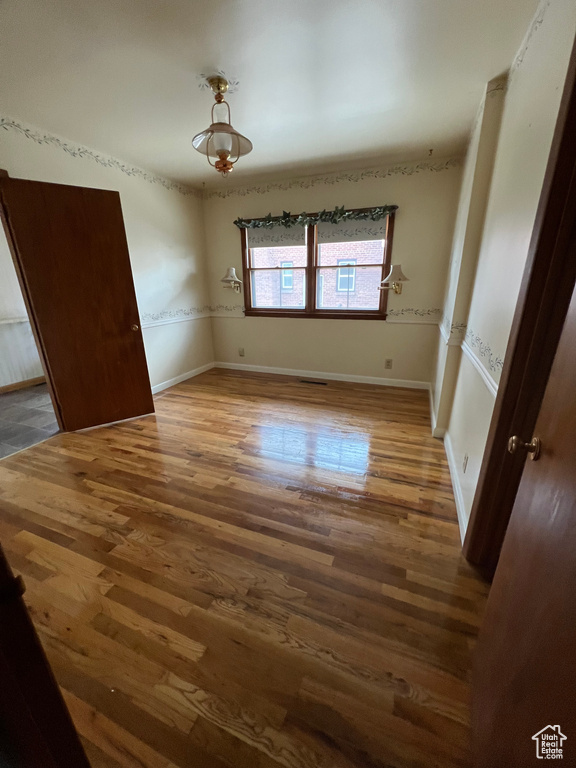 Unfurnished bedroom with wood finished floors and baseboards