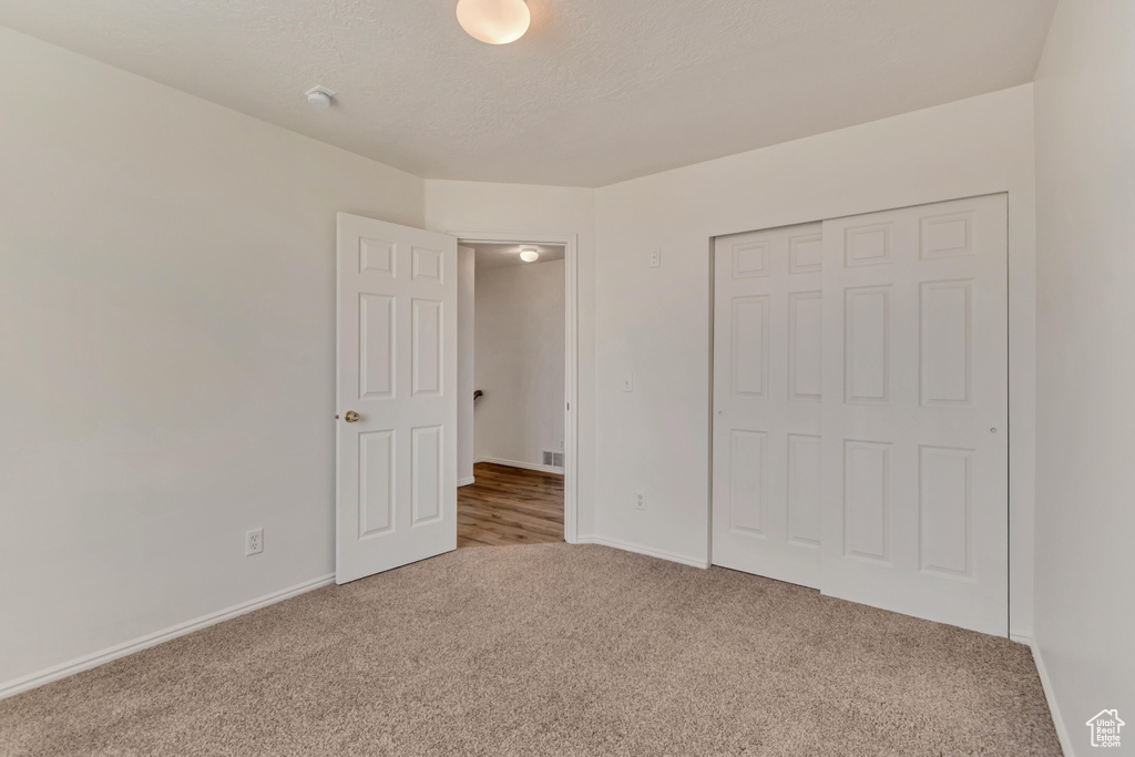 Unfurnished bedroom with baseboards, a closet, and carpet floors