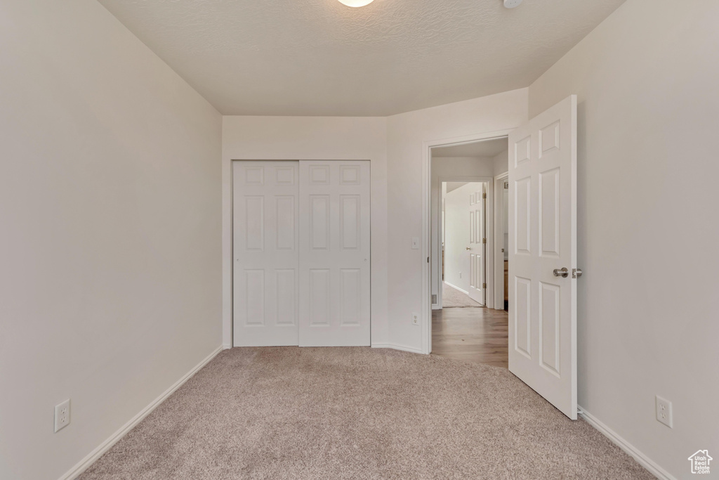 Unfurnished bedroom featuring carpet, a closet, and baseboards