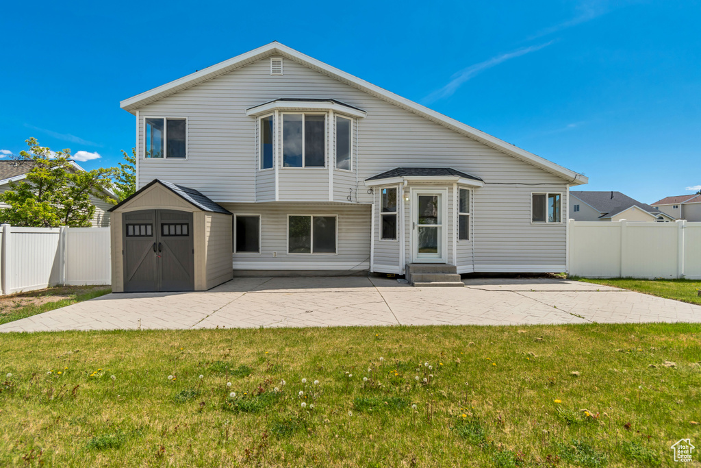 Tri-level home with a patio area, a storage shed, fence private yard, entry steps, and a front lawn