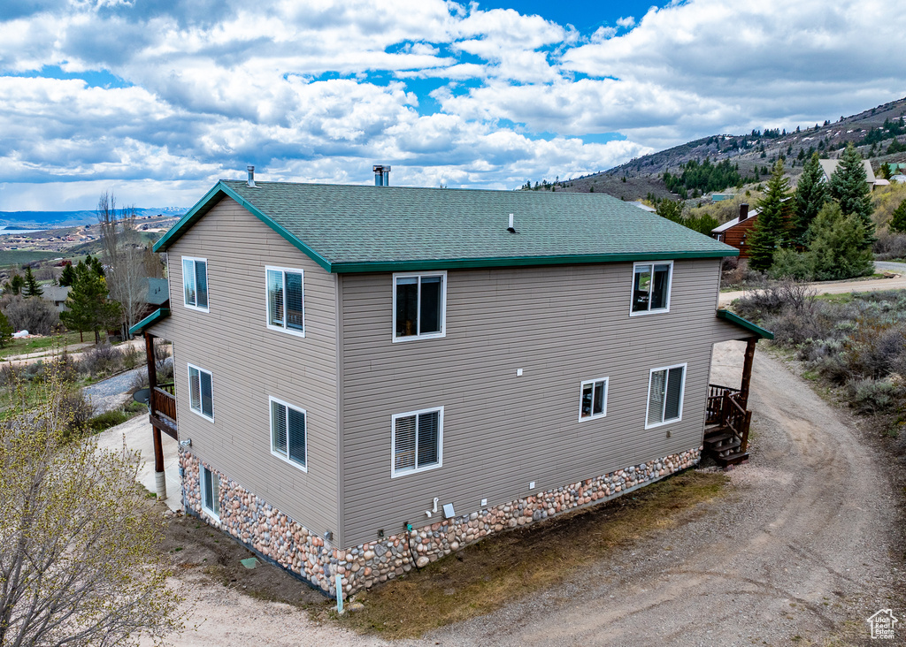 View of home\\\\\\\\\\\\\\\\\\\\\\\\\\\\\\\'s exterior with dirt driveway, roof with shingles, and a mountain view
