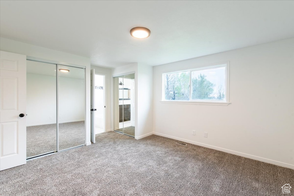 Unfurnished bedroom featuring visible vents, carpet flooring, and baseboards