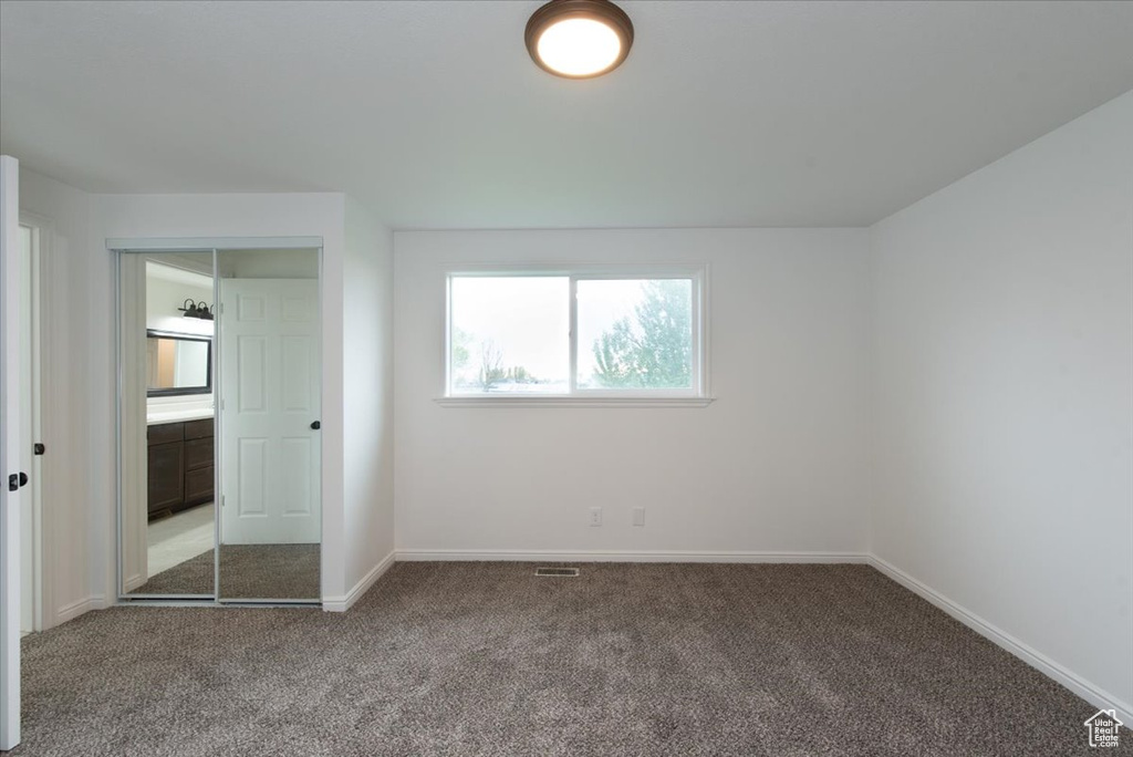 Unfurnished bedroom with baseboards, visible vents, and carpet