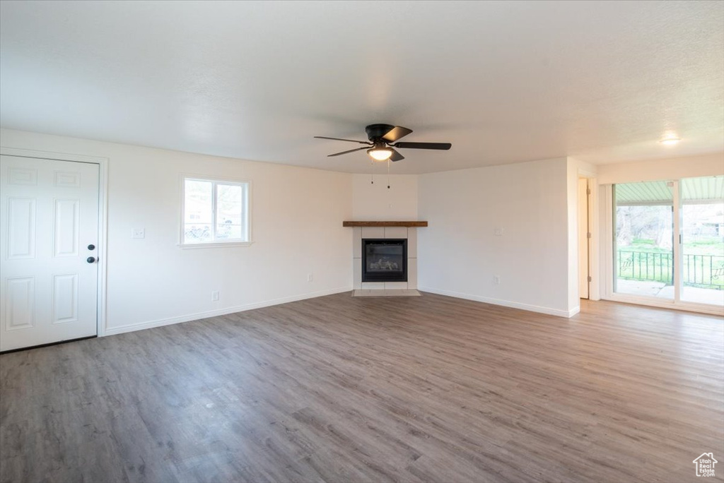 Unfurnished living room featuring a ceiling fan, plenty of natural light, and wood finished floors