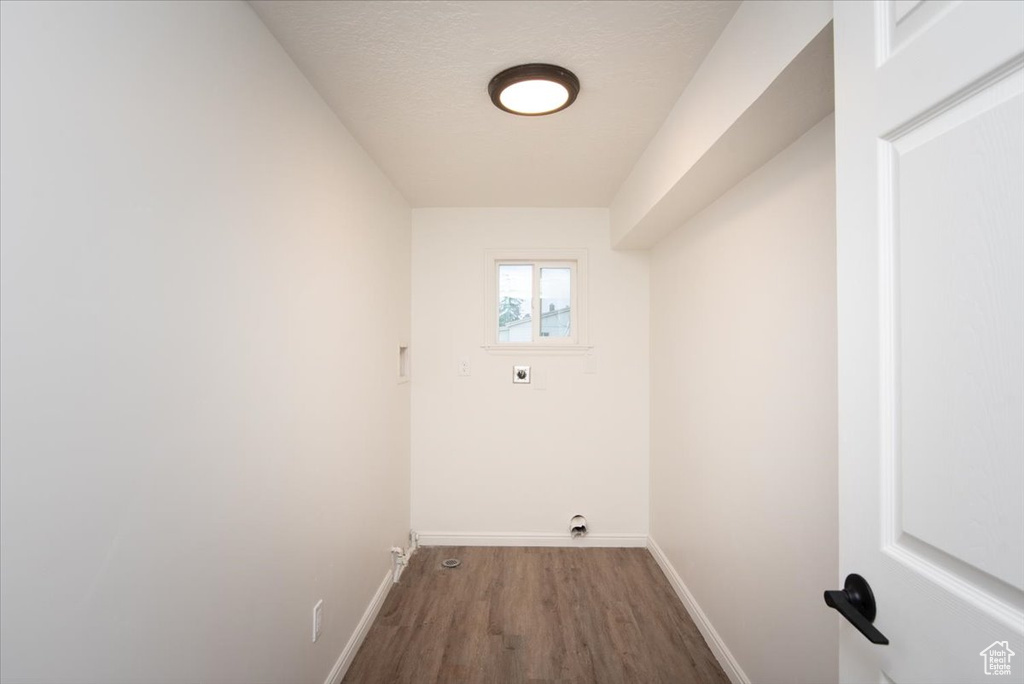 Washroom featuring baseboards, laundry area, electric dryer hookup, and wood finished floors