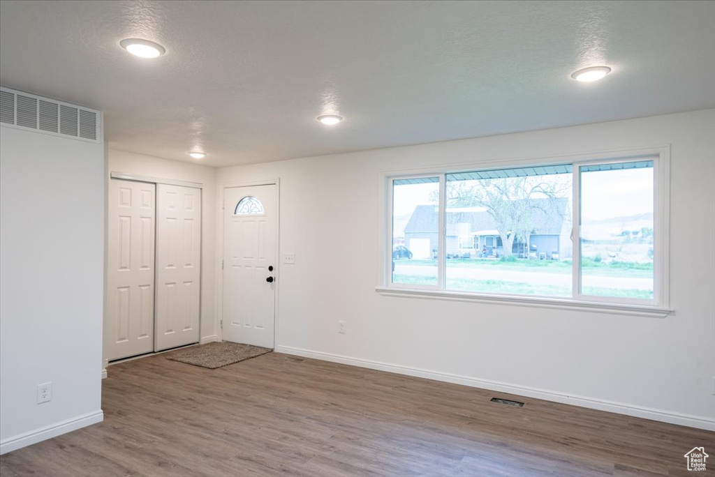 Foyer entrance featuring baseboards, visible vents, and wood finished floors