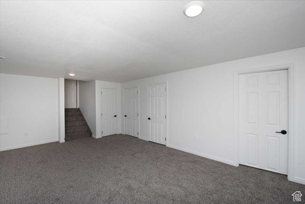 Basement with baseboards, carpet, and stairway